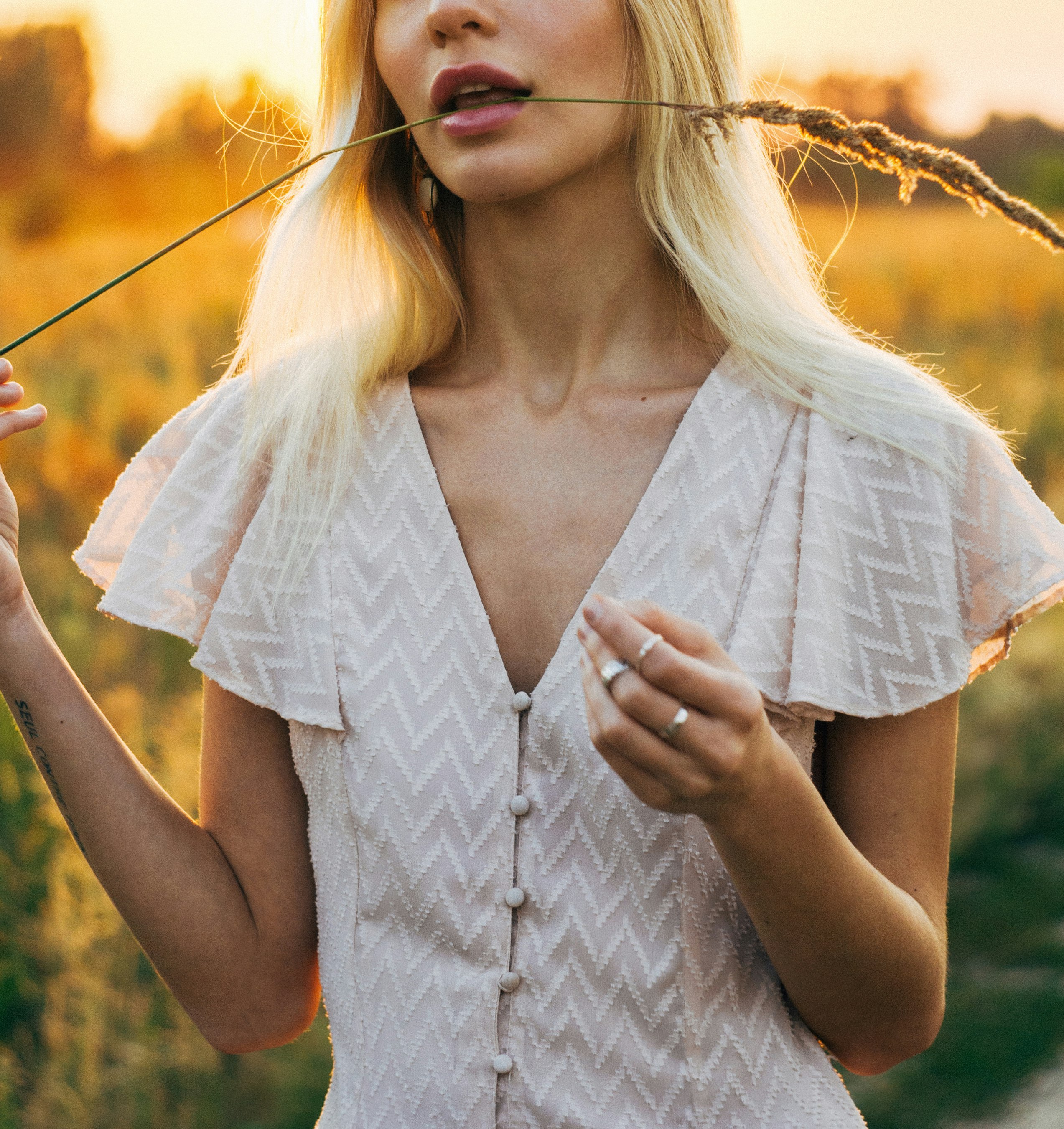 woman in white dress holding a red and yellow flower during daytime